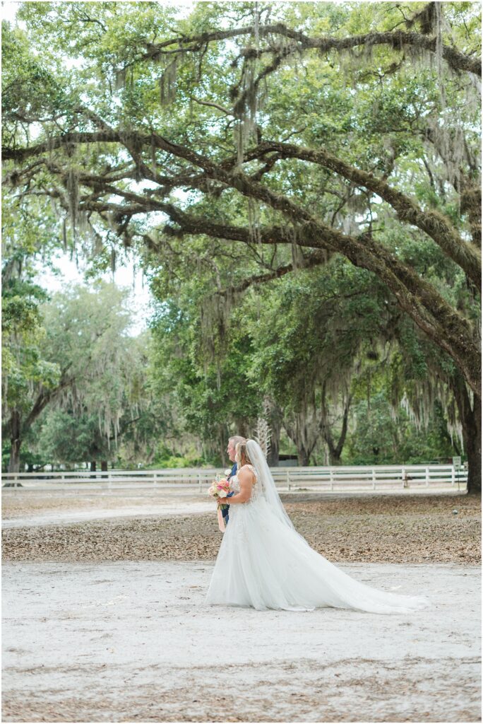 Bride walking down the aisle beneath oak trees at Chandler Oaks Wedding Venue