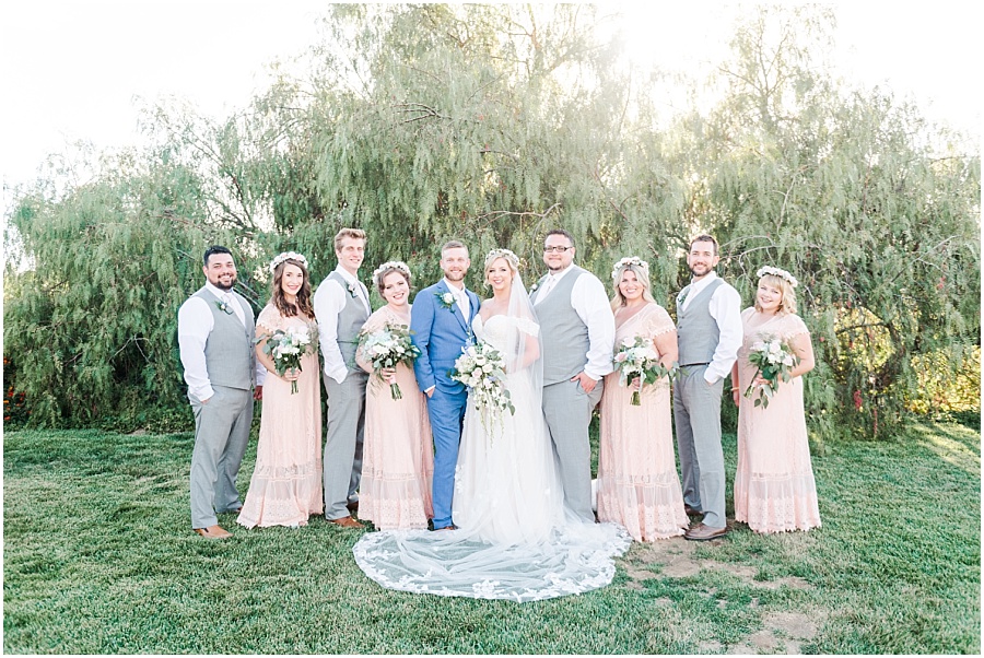 Escondido Wedding Photographer. Wedding party pictures with bridesmaids in peach long dresses and groomsmen wearing gray vests