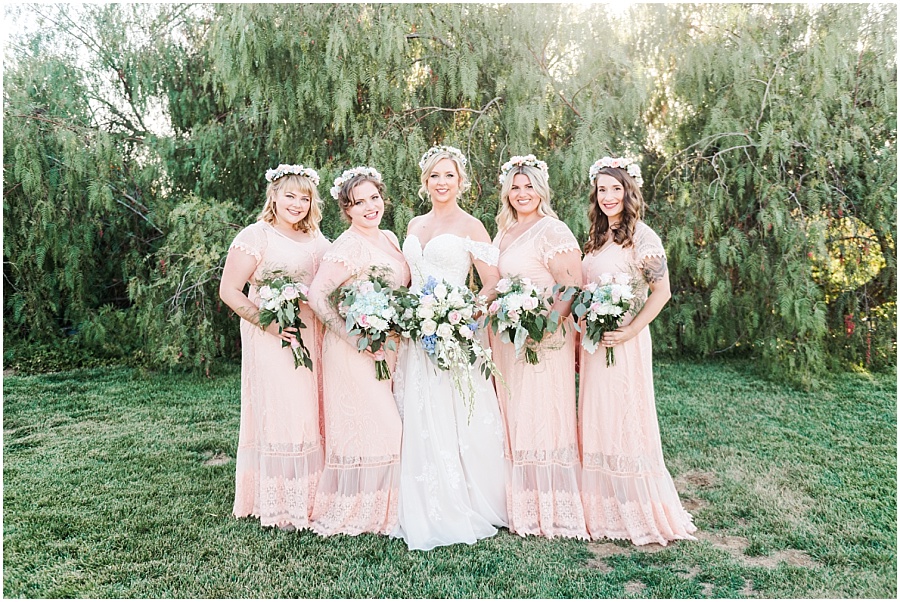 Bridesmaids pictures wearing peach long dresses and flower crowns in their hair.