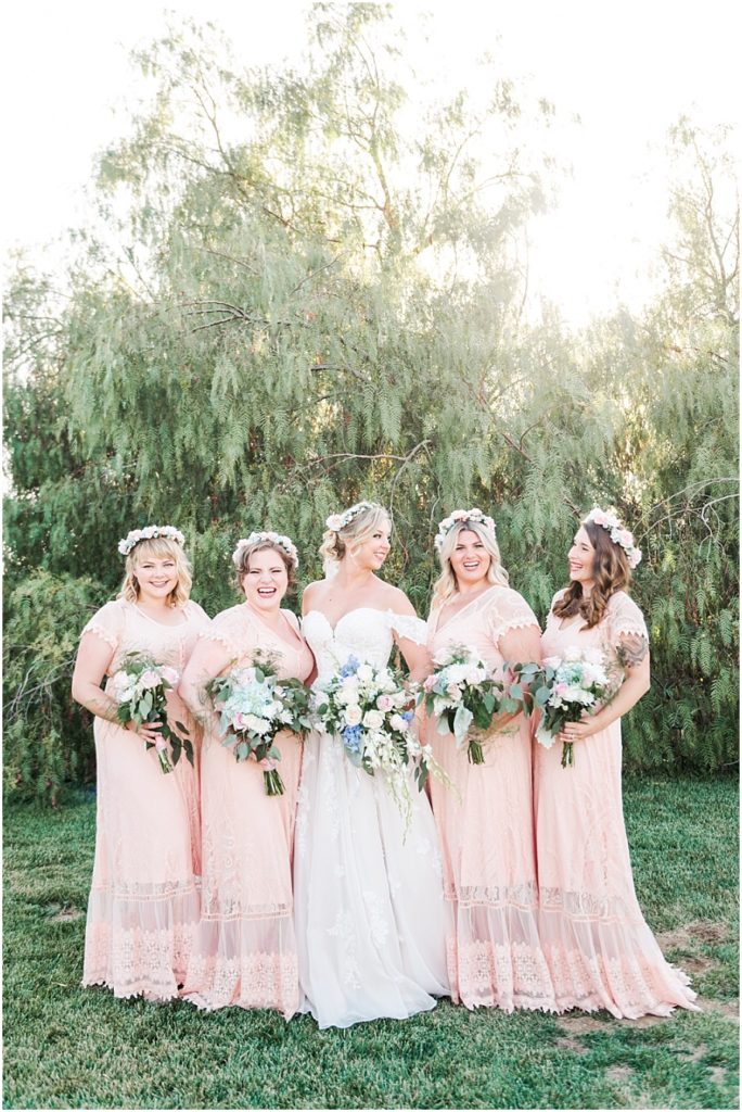 Bridesmaids pictures wearing peach long dresses and flower crowns in their hair.