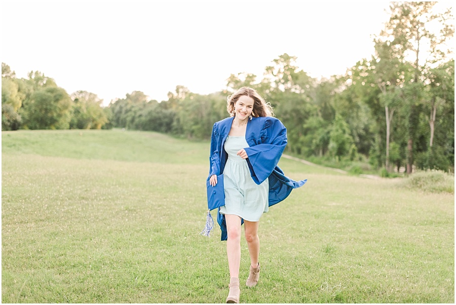 Houston senior session in the wildflowers on the Terry Hershey Trail in cap and gown running through the field