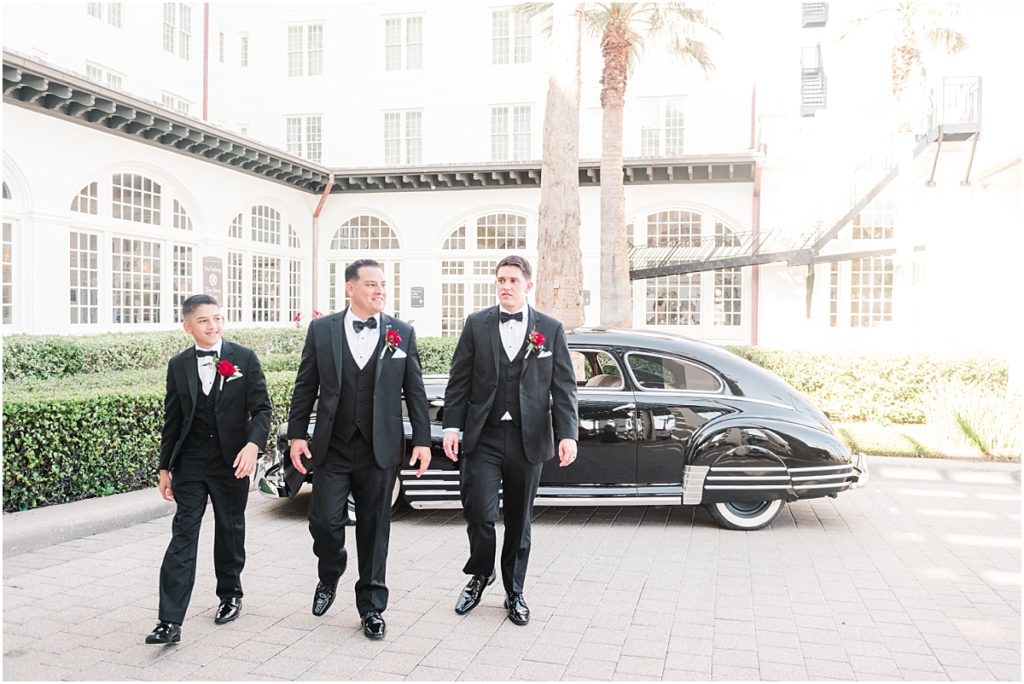 Groomsmen with a vintage car in front of the Galvez Hotel in Galveston