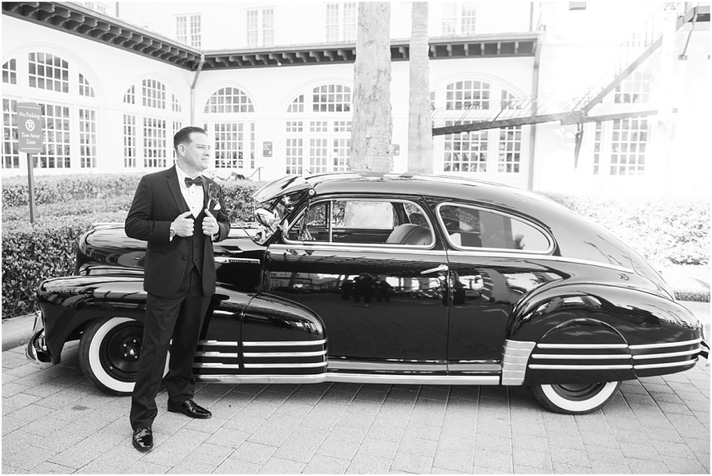 Groom with a vintage car in front of the Galvez Hotel in Galveston