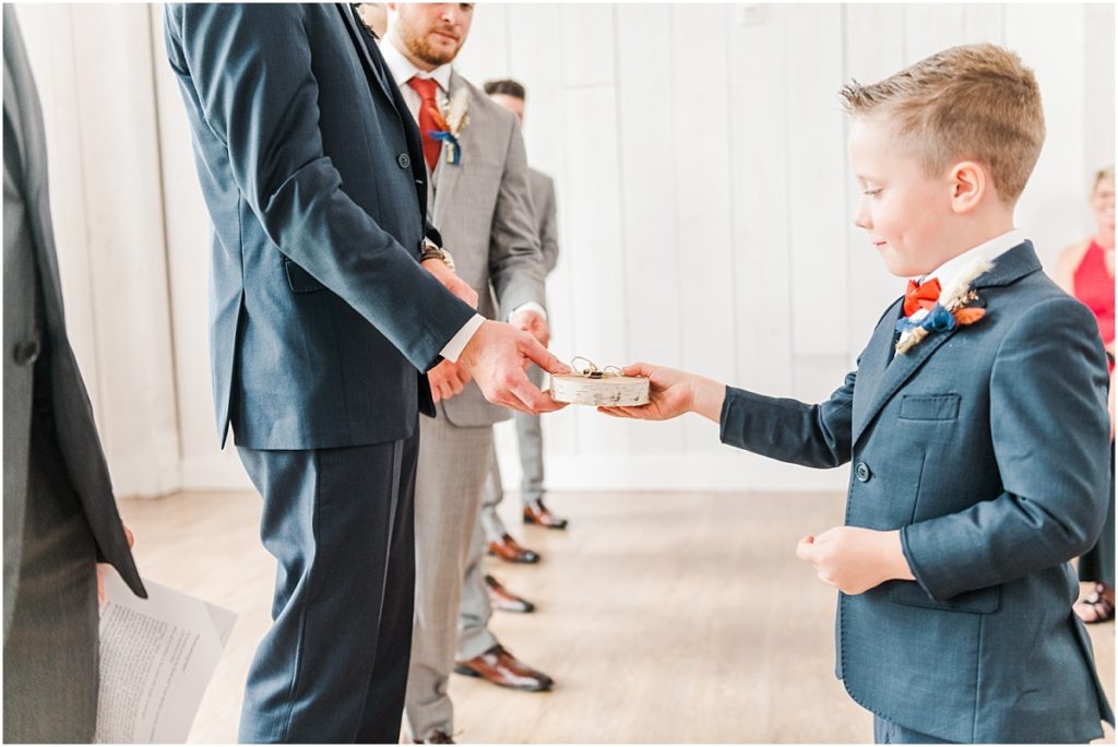 Ring bearer handing off the ring during an indoor ceremony at The Springs Wallisville.