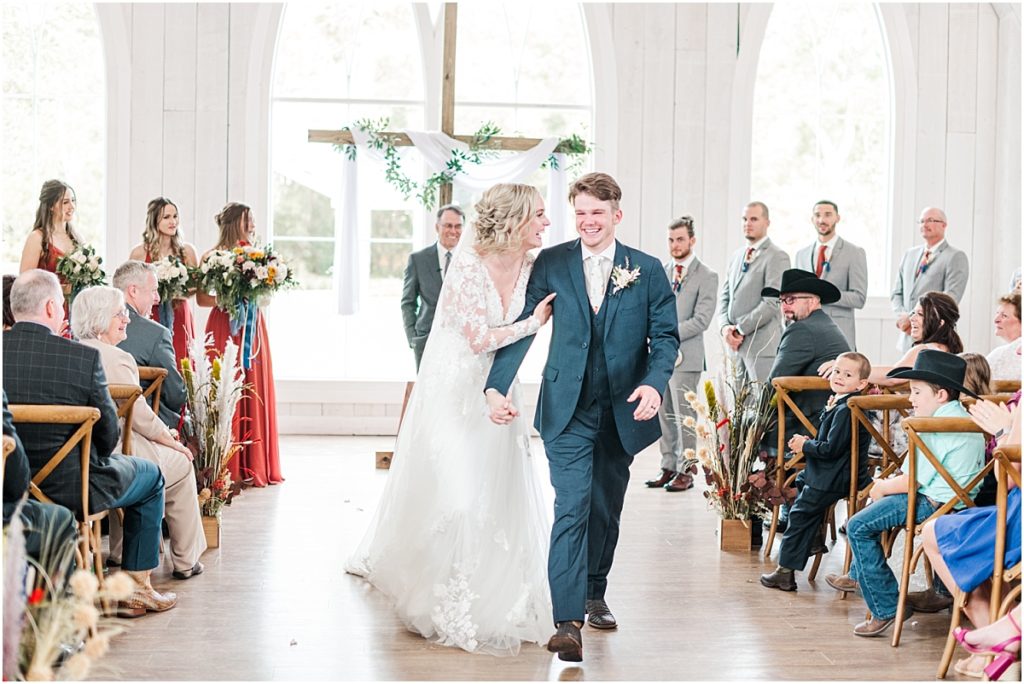 Bride and groom recessional during an Indoor wedding ceremony at The Springs Wallisville.