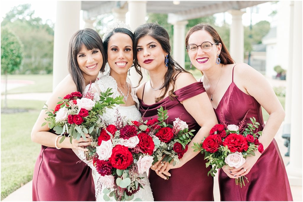 Bridesmaids pictures at Ashton Gardens west with red floral details and maroon bridesmaids dresses.