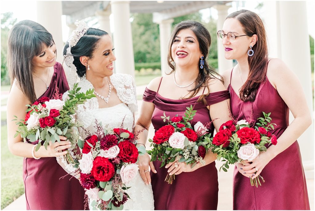 Bridesmaids pictures at Ashton Gardens west with red floral details and maroon bridesmaids dresses.