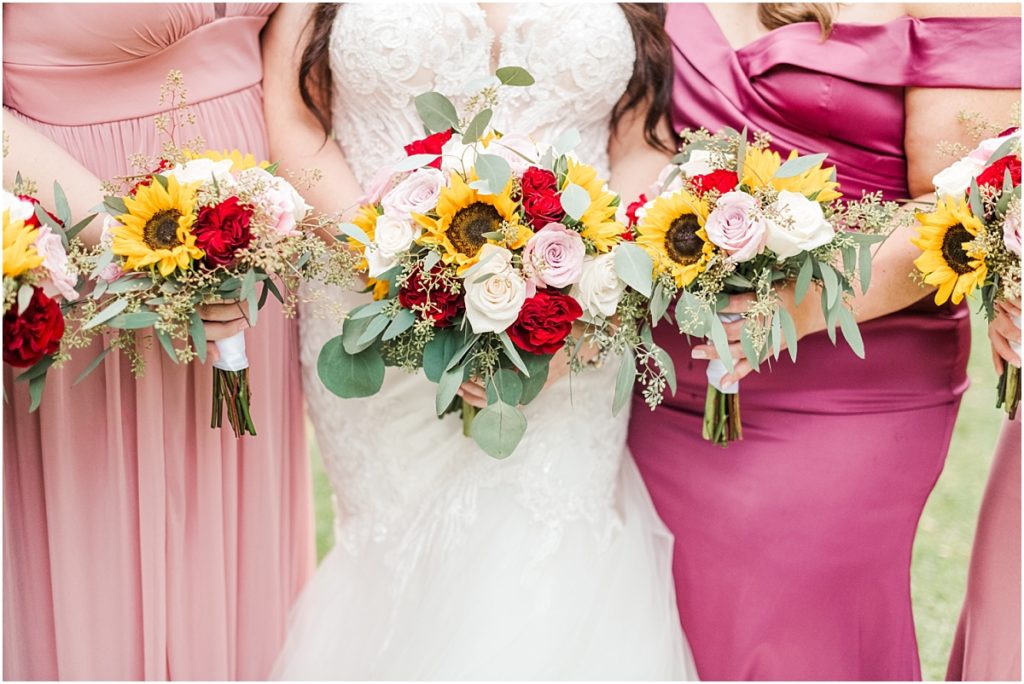 Bridesmaids pictures with pink bridesmaids dresses and sunflower and rose bouquets