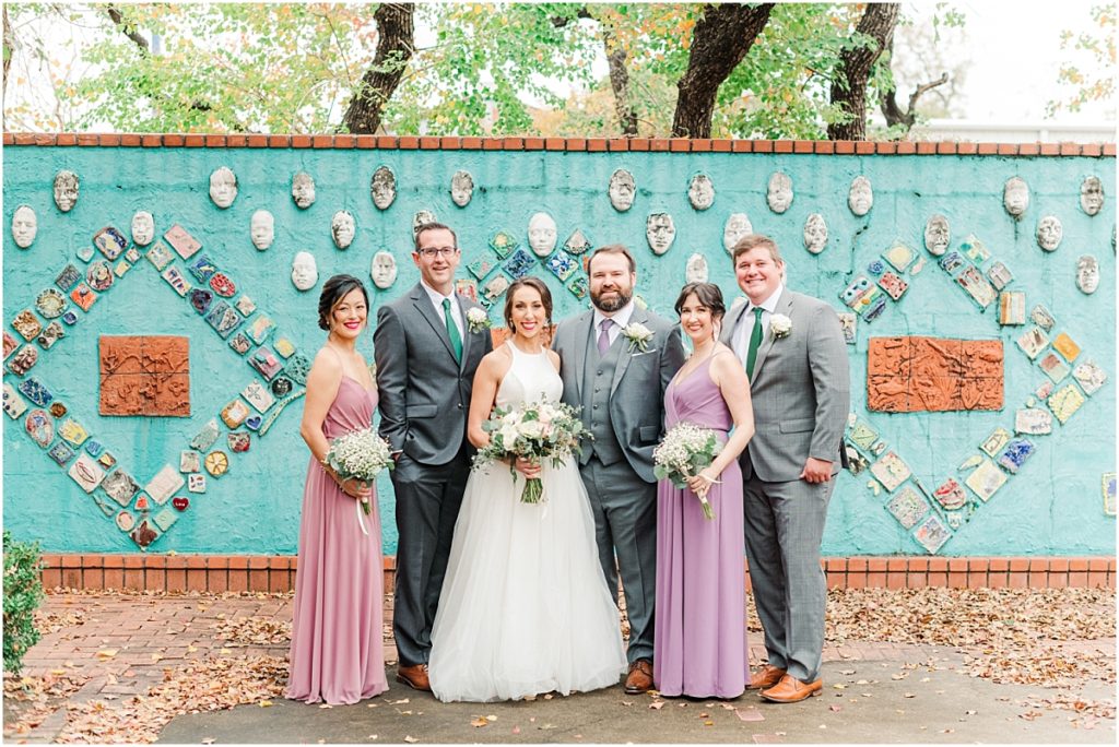 Wedding party pictures in front the tourquoise wall of faces next to St. Joseph's Catholic Church in Houston