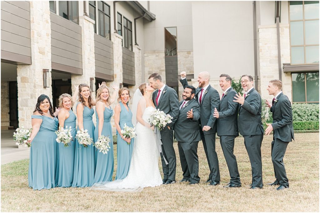 Bridesmaids in dusty blue dress and groomsmen in rust ties