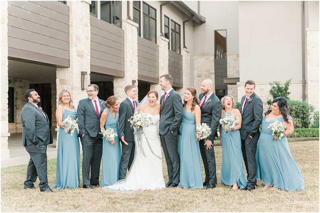 Bridesmaids in dusty blue dress and groomsmen in rust ties