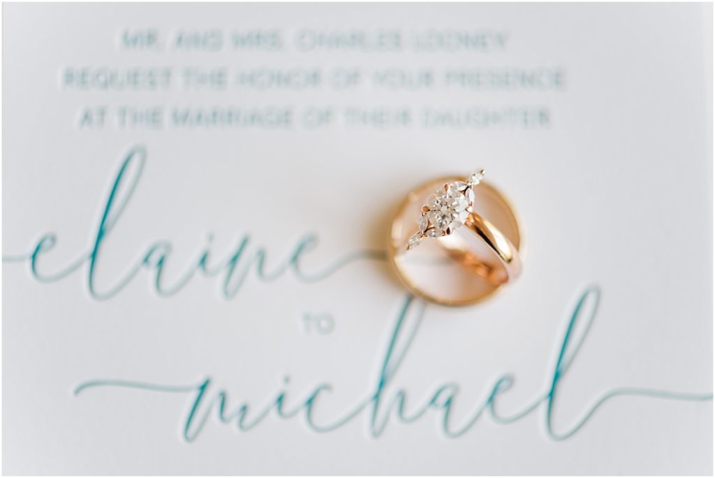 Gold rings and teal embossed invitation