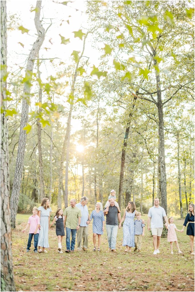 Extended family pictures of a big family wearing blue walk through a park in Jacksonville