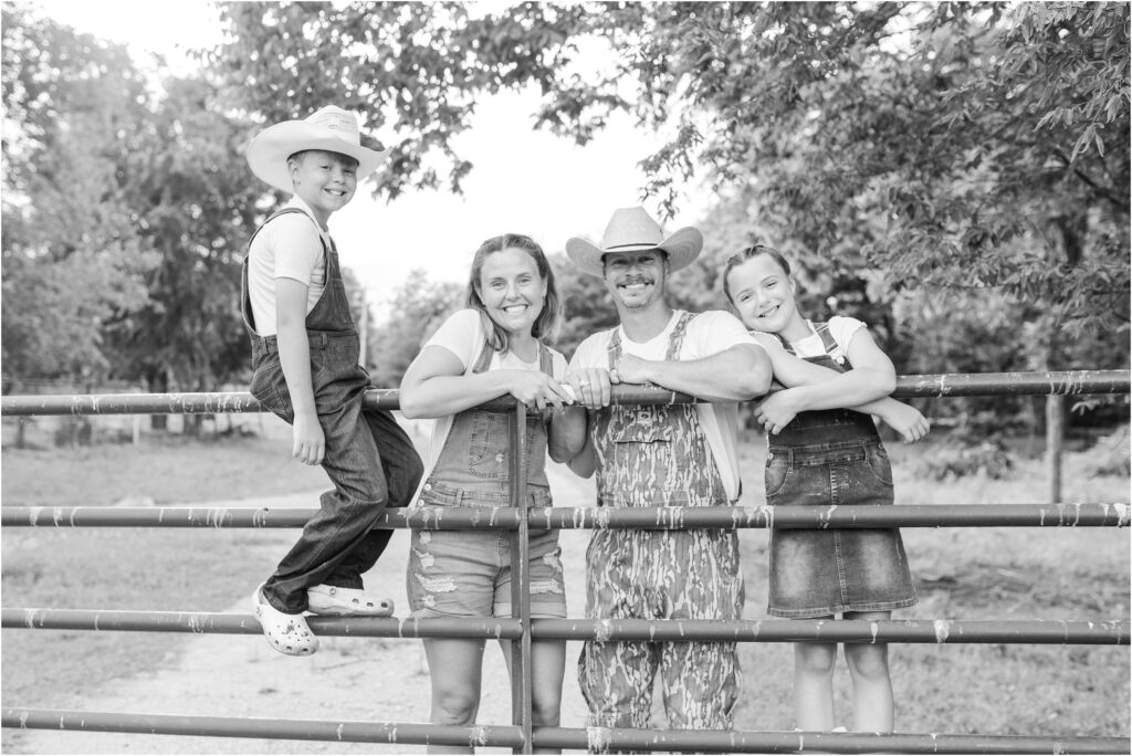 Family standing on the gate to the farm in college station