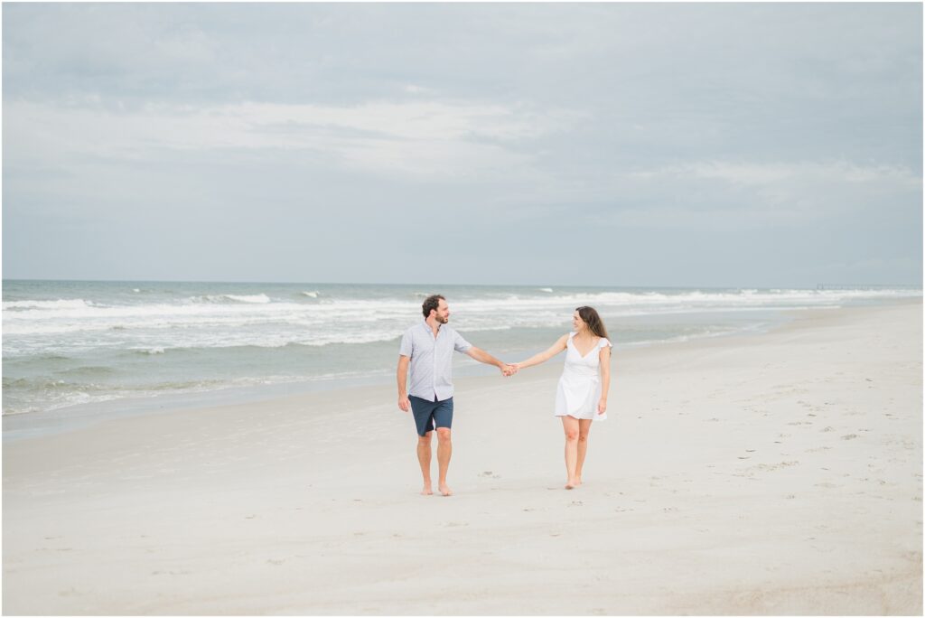 Couple walking on the beach in Jacksonville for their engagement session